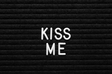 Photo of Phrase Kiss Me on black textured surface