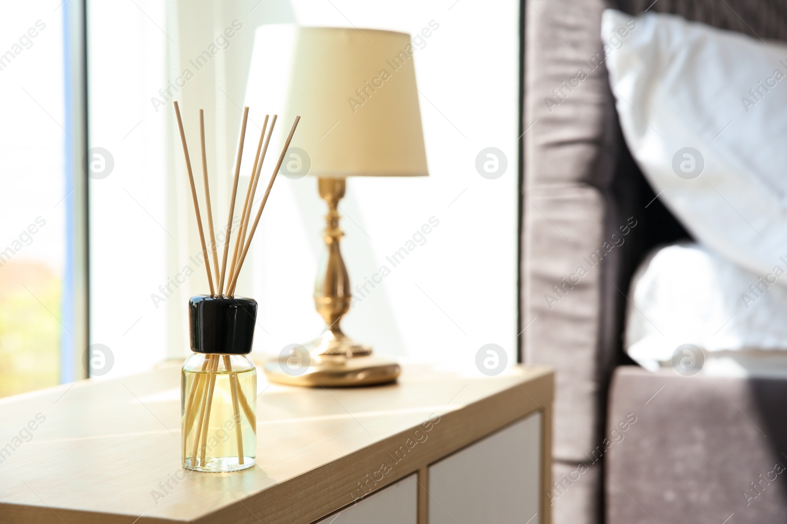 Photo of Aromatic reed air freshener on table indoors