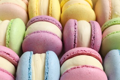 Many delicious colorful macarons as background, closeup