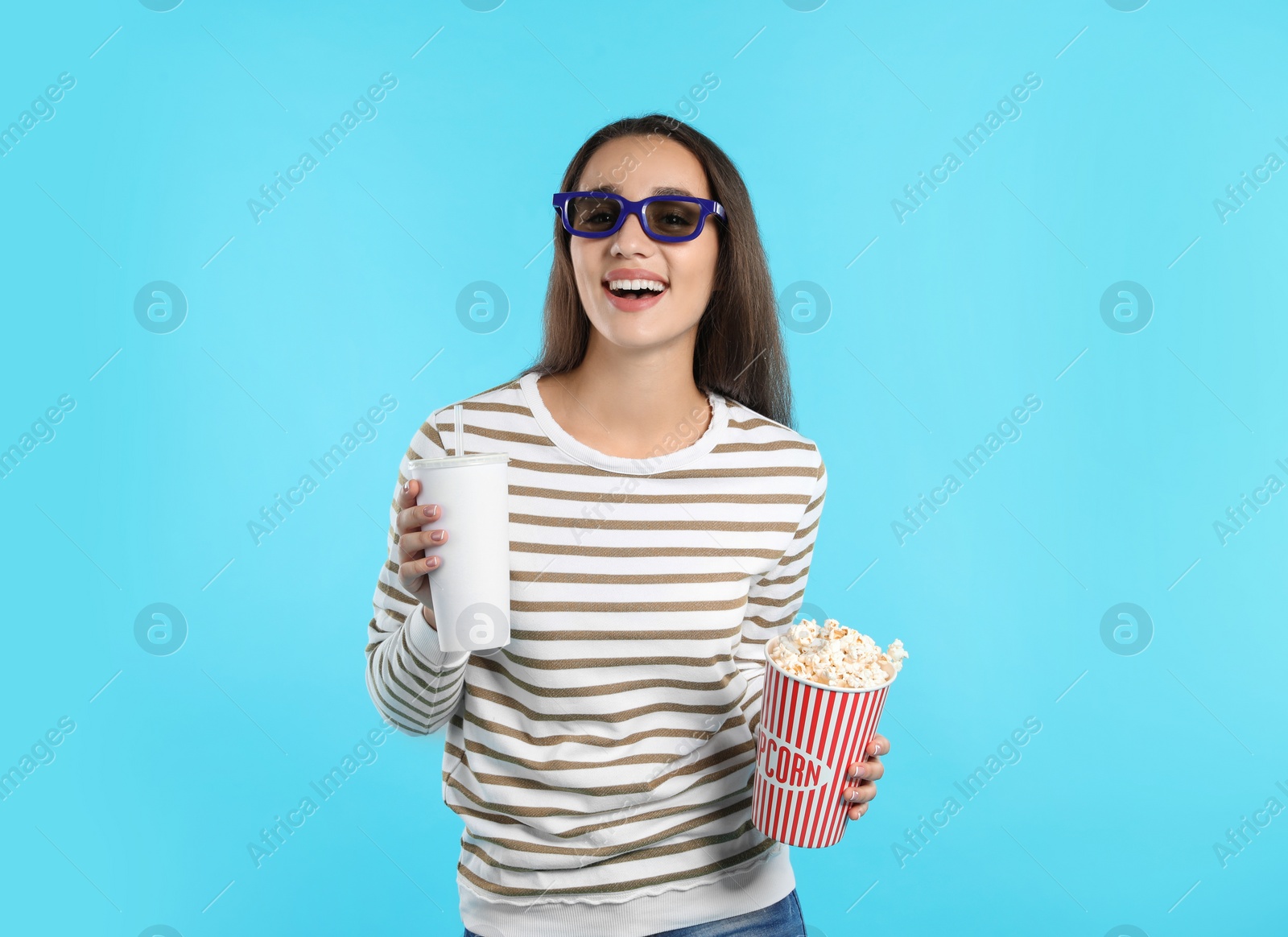 Photo of Woman with 3D glasses, popcorn and beverage during cinema show on color background