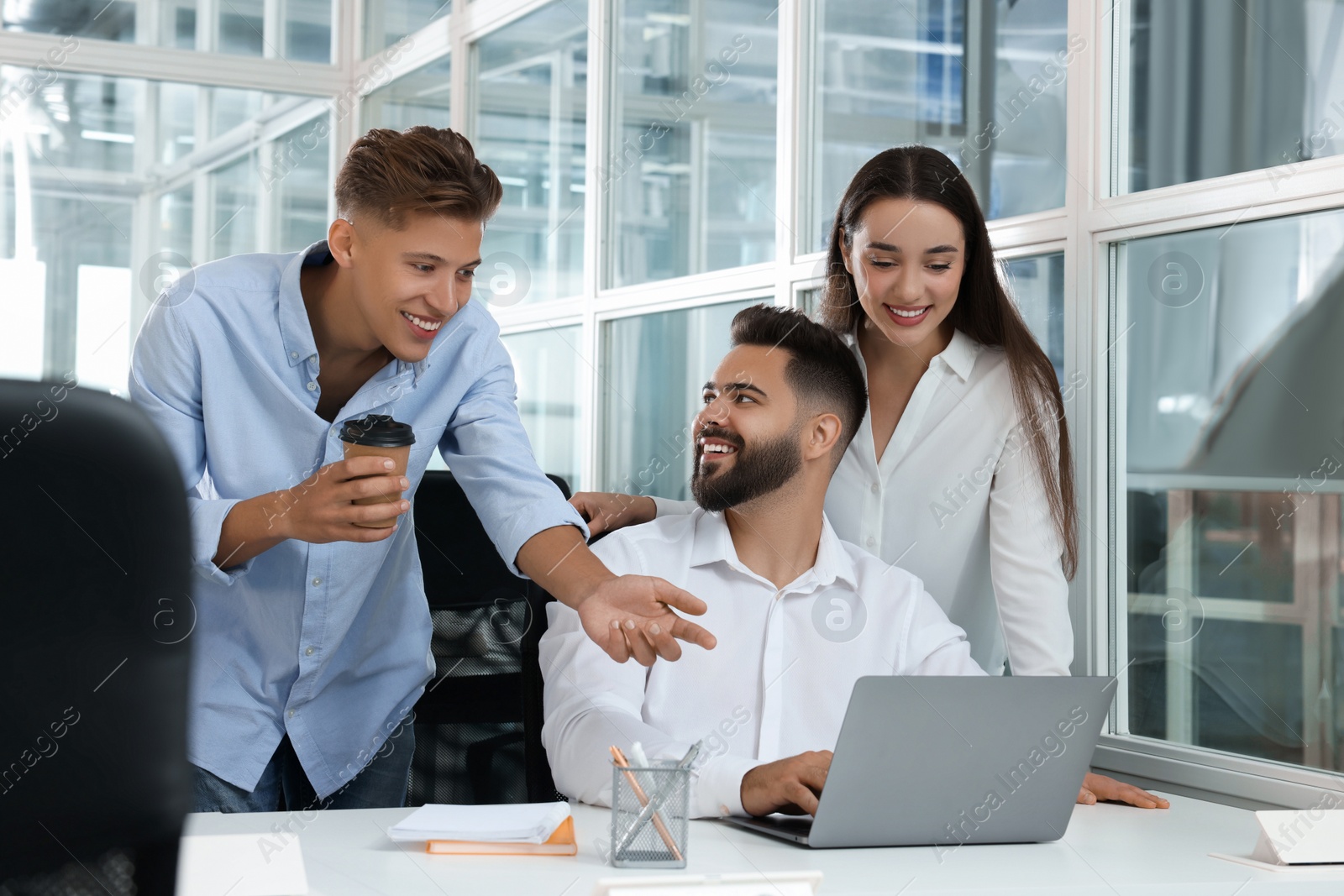 Photo of Colleagues working together in open plan office