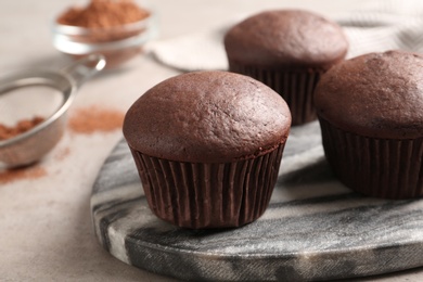 Delicious fresh chocolate cupcakes on grey table, closeup