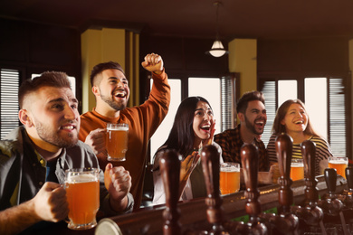 Group of friends watching football in sport bar