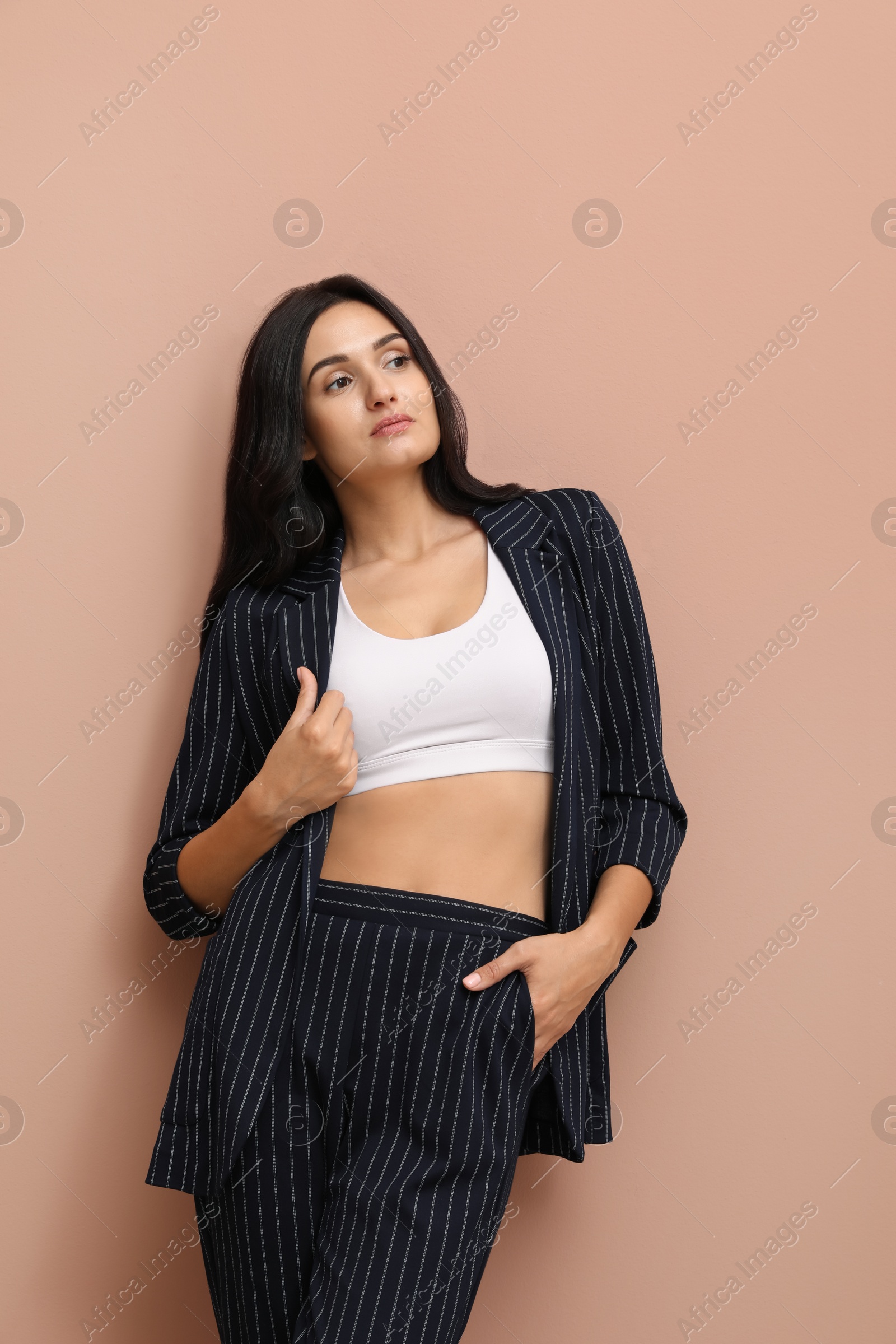 Photo of Beautiful woman in formal suit on pale pink background. Business attire