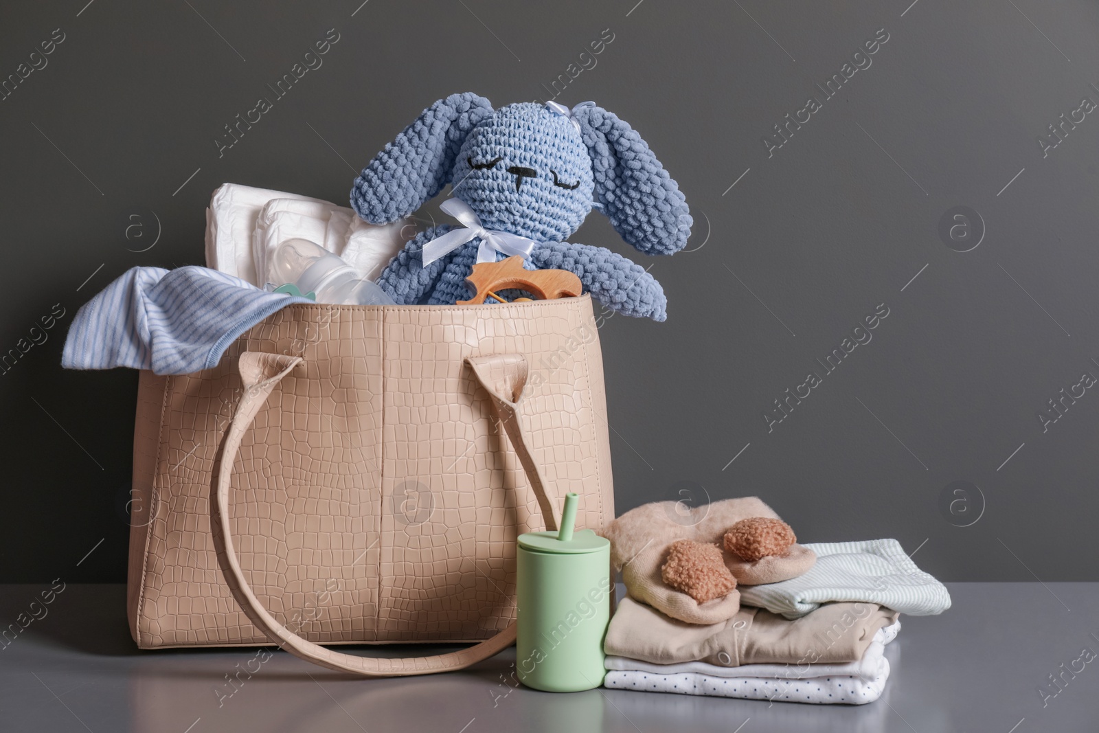 Photo of Mother's bag with baby's stuff on gray commode