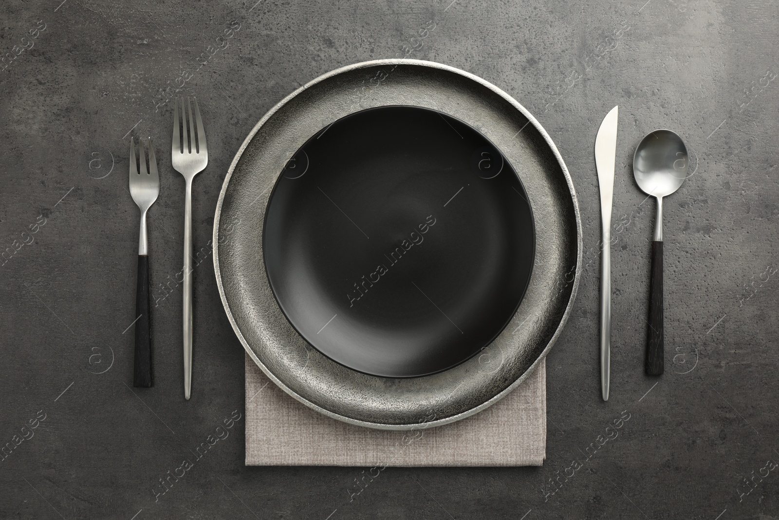 Photo of Stylish setting with cutlery and plates on black table, flat lay