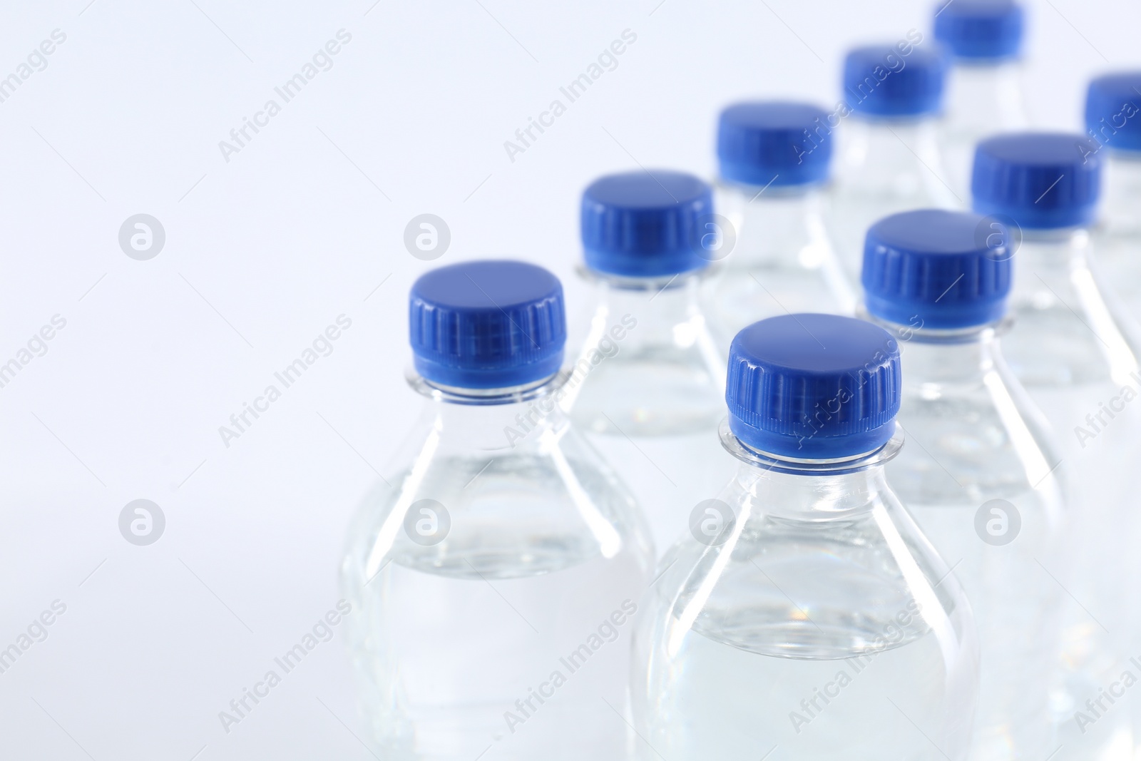 Photo of Plastic bottles with pure water on white background, closeup