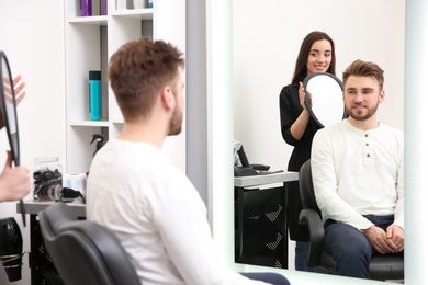 Photo of Professional female hairdresser working with client in salon