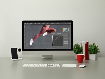 Image of Designer's workplace. Computer with photo editor application on table 