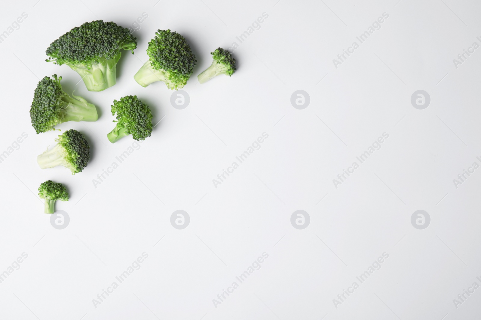 Photo of Flat lay composition with fresh green broccoli on light background. Space for text