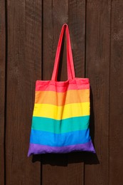 Photo of Rainbow bag hanging on wooden background. LGBT pride