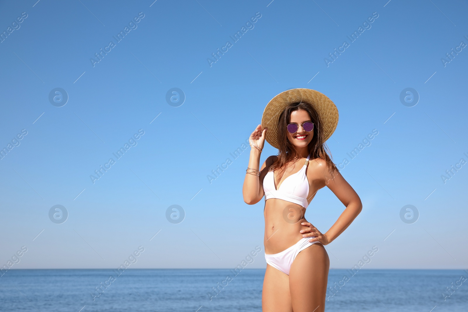 Photo of Young woman with beautiful body on beach. Space for text