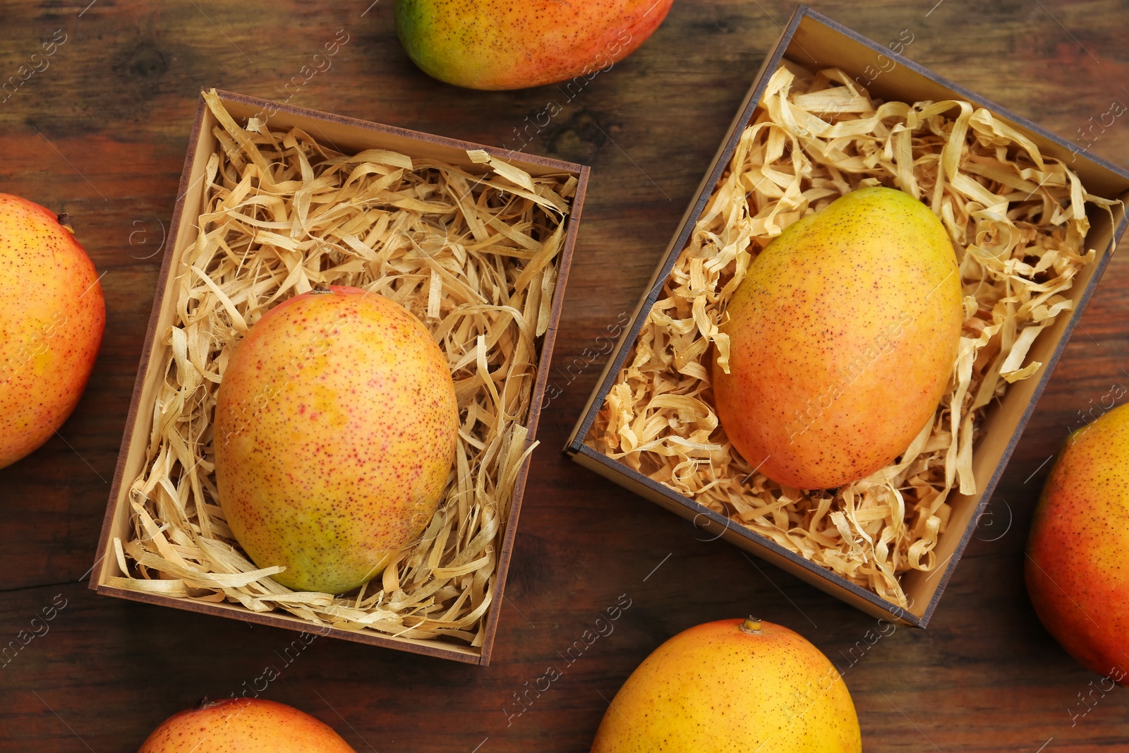 Photo of Delicious ripe juicy mangos on wooden table, flat lay