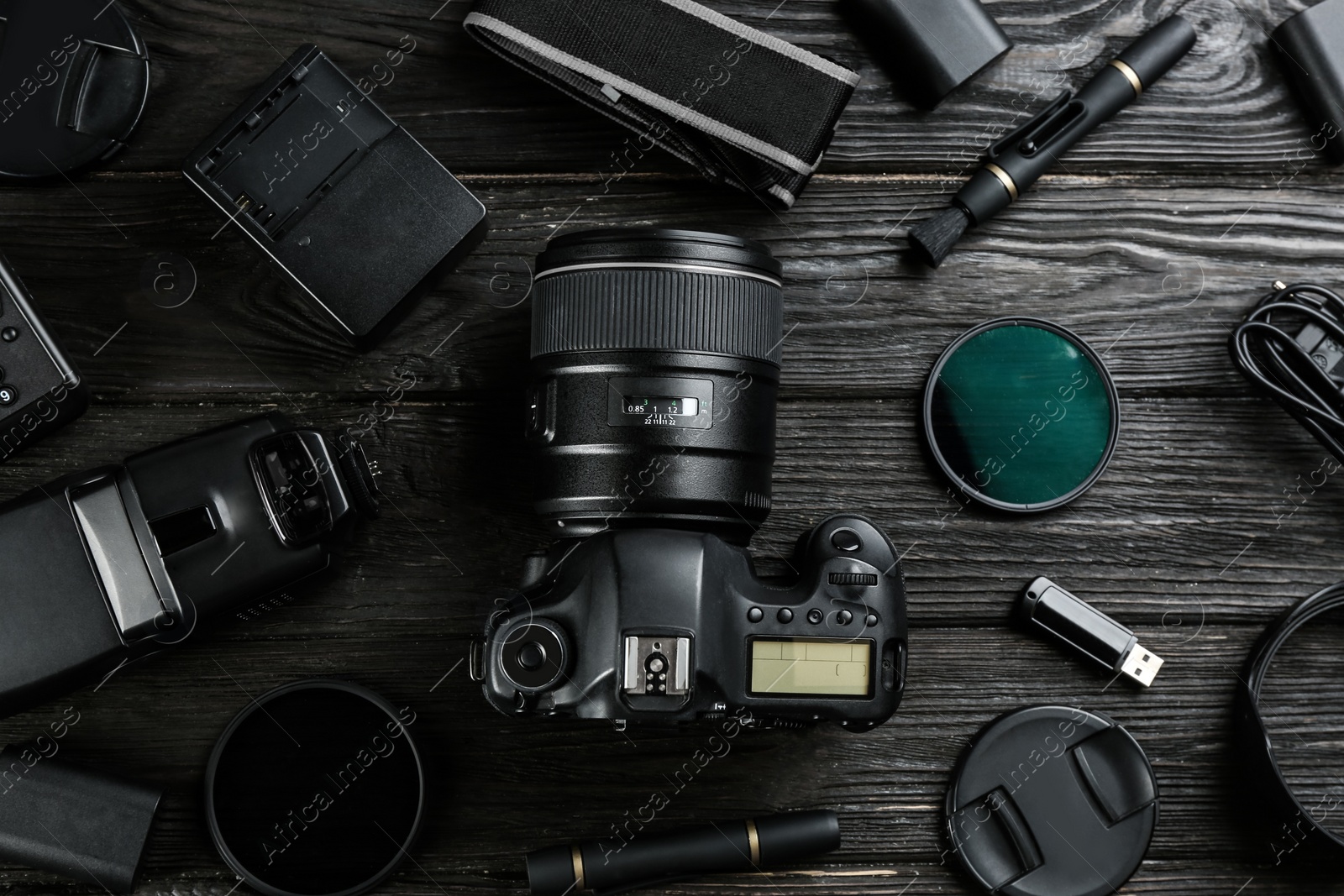 Photo of Flat lay composition with equipment for professional photographer on black wooden table