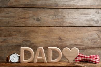 Photo of Composition with word DAD and heart on wooden background, space for text. Happy Father's day
