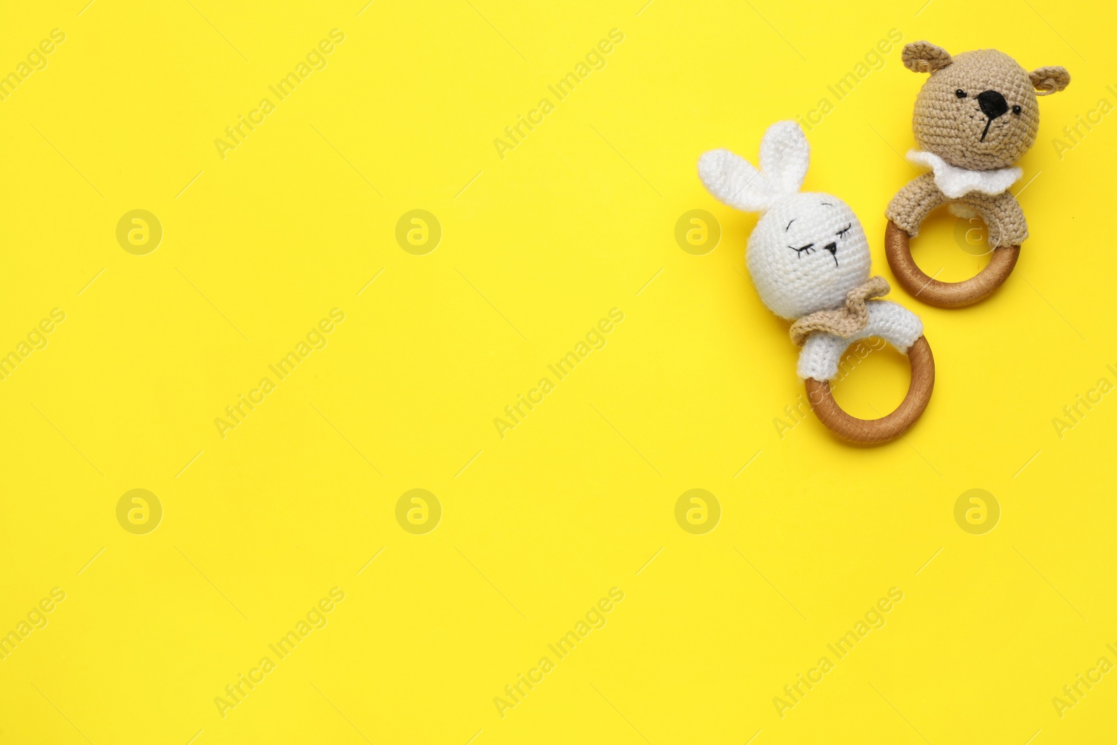 Photo of Baby teether toys on yellow background, flat lay. Space for text