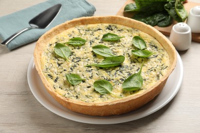 Photo of Delicious homemade spinach pie on white wooden table