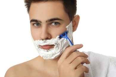 Photo of Handsome young man shaving with razor on white background, closeup