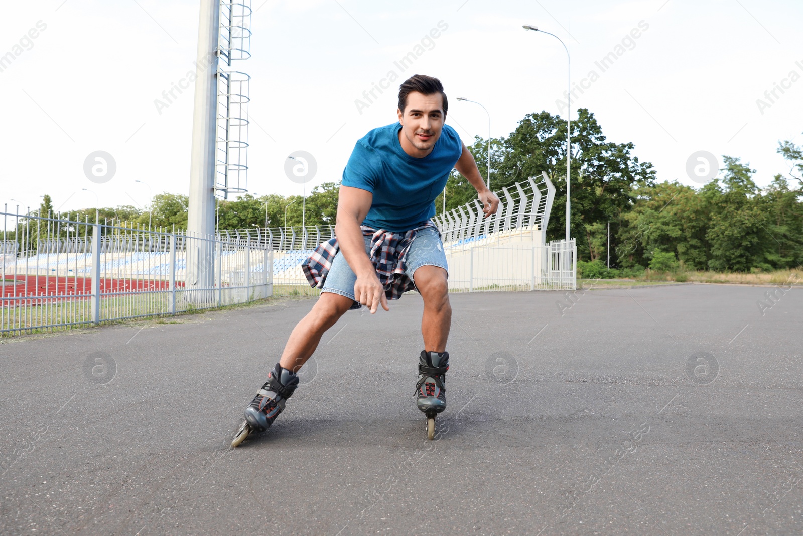 Photo of Handsome young man roller skating outdoors. Recreational activity