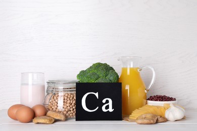 Photo of Food high in calcium. Different products on white wooden table