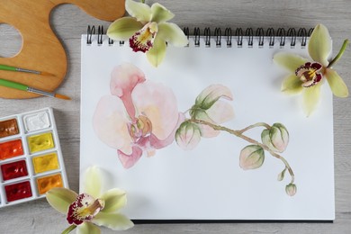 Flat lay composition with beautiful drawing of orchid
flowers on wooden table
