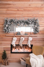 Photo of Fireplace with Christmas stockings in room. Festive interior