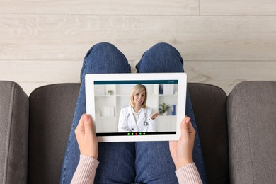 Online medical consultation. Woman having video chat with doctor via tablet at home, top view
