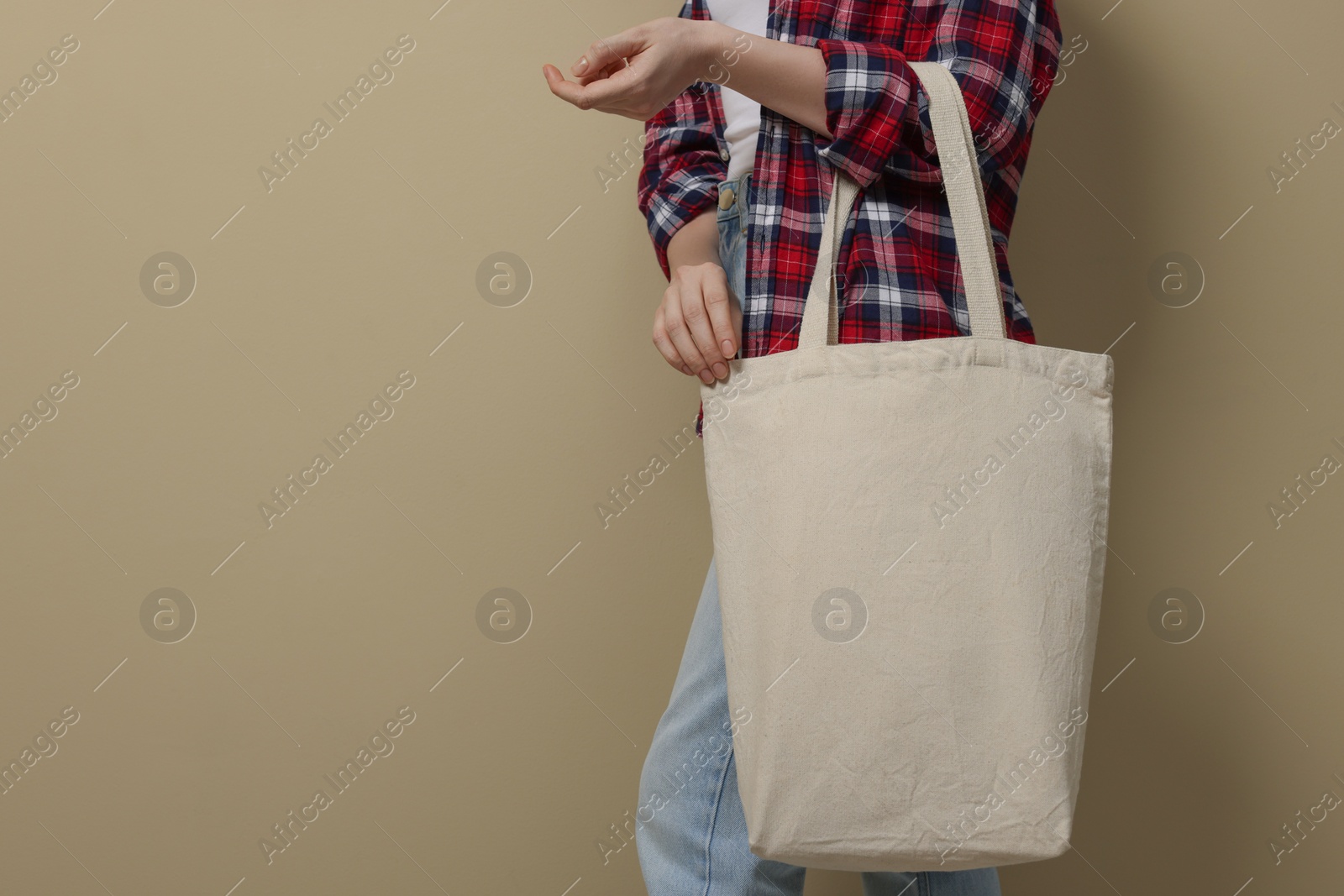 Photo of Woman with eco bag on beige background, closeup. Space for text