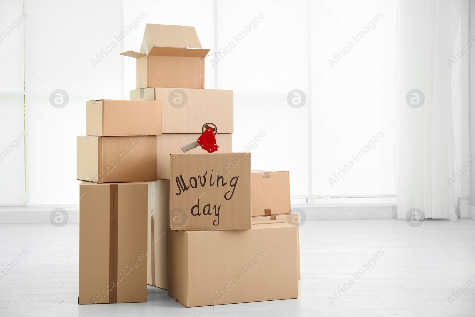 Photo of Pile of moving boxes in empty room