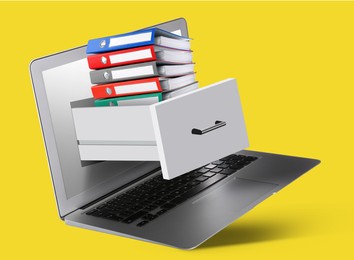 Image of Digital archive. Drawer with stacked folders sticking out of laptop screen on yellow background
