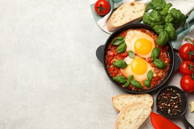 Photo of Delicious Shakshuka served on light grey table, flat lay. Space for text