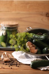 Photo of Fresh cucumbers, dill, peppercorns and garlic on wooden table. Pickling recipe