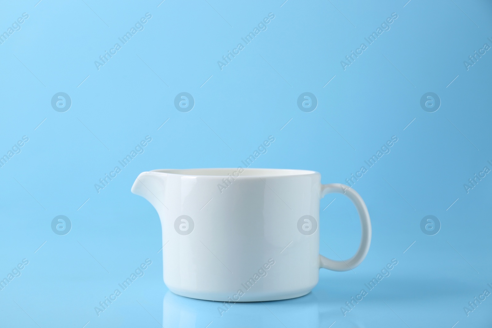 Photo of One jug on light blue background, space for text