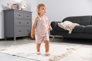 Photo of Cute baby learning to walk in living room