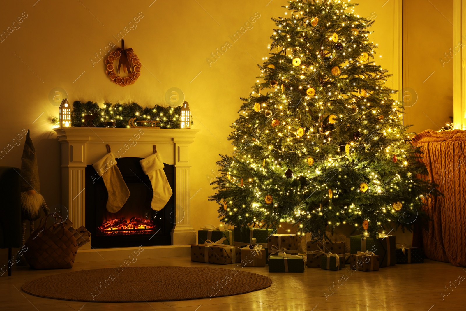 Photo of Stylish fireplace near decorated Christmas tree and accessories in cosy room