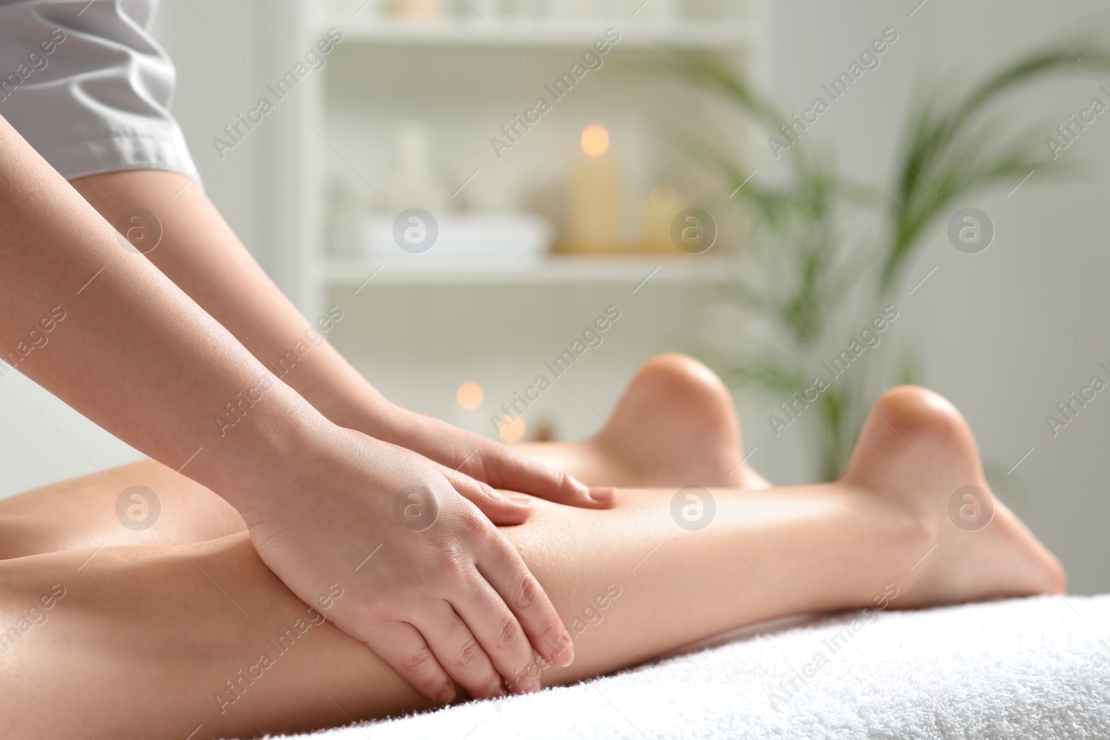 Photo of Woman receiving leg massage in spa salon, closeup