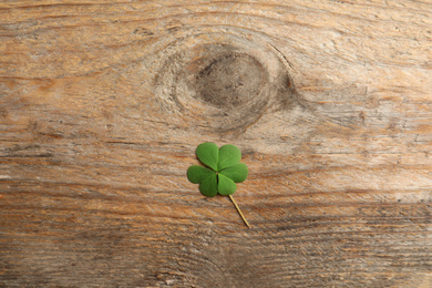 Photo of Clover leaf on wooden table, top view. St. Patrick's Day symbol