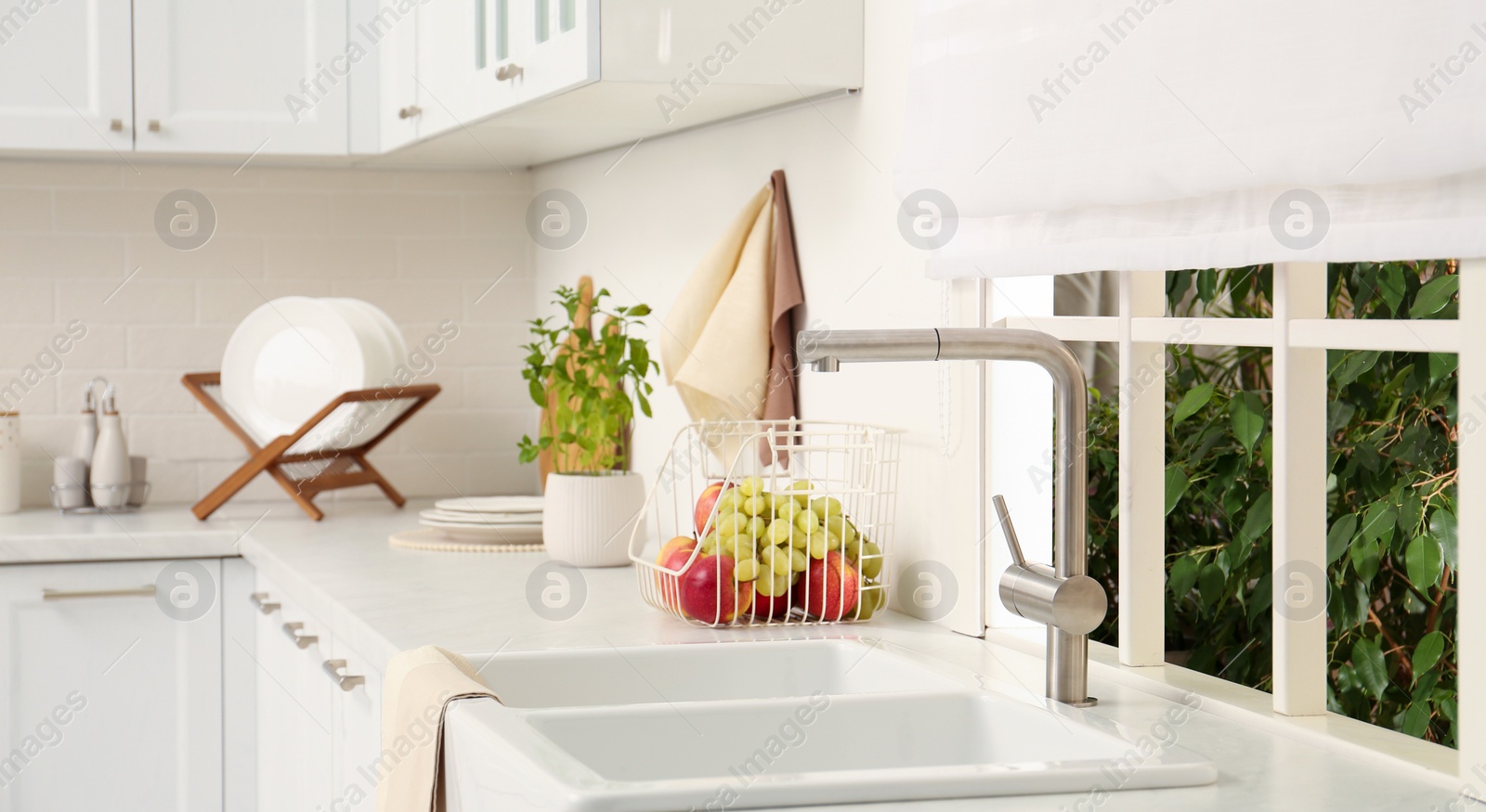 Image of White sink with tap near window in kitchen. Interior design