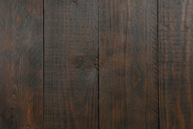 Texture of dark brown wooden surface as background, closeup