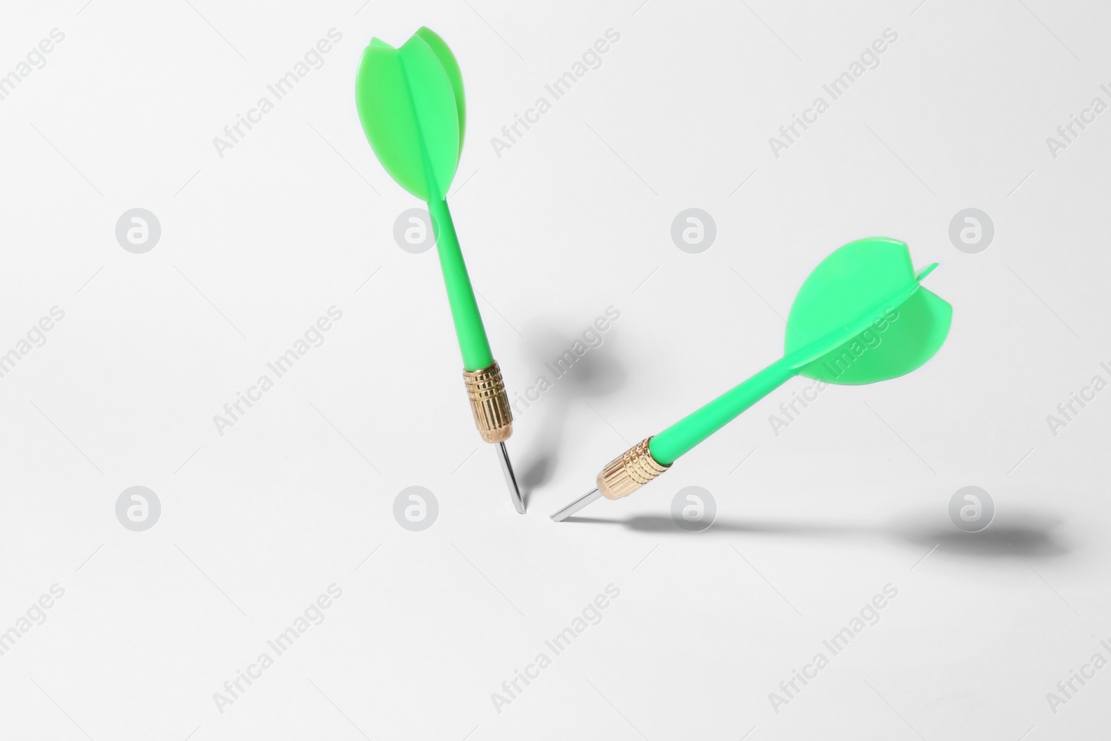 Photo of Green dart arrows for game on white background