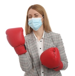 Photo of Emotional businesswoman with protective mask and boxing gloves on white background. Strong immunity concept