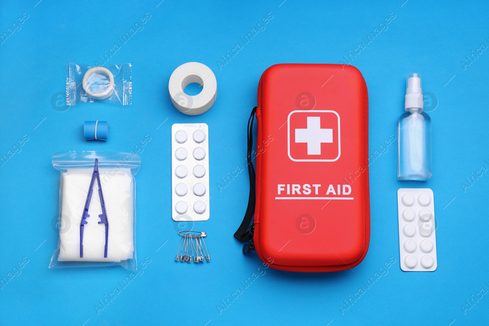 Photo of Flat lay composition with first aid kit on light blue background