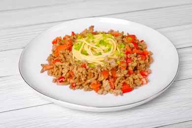 Tasty minced meat with spaghetti, vegetables and green onion on white wooden table, closeup