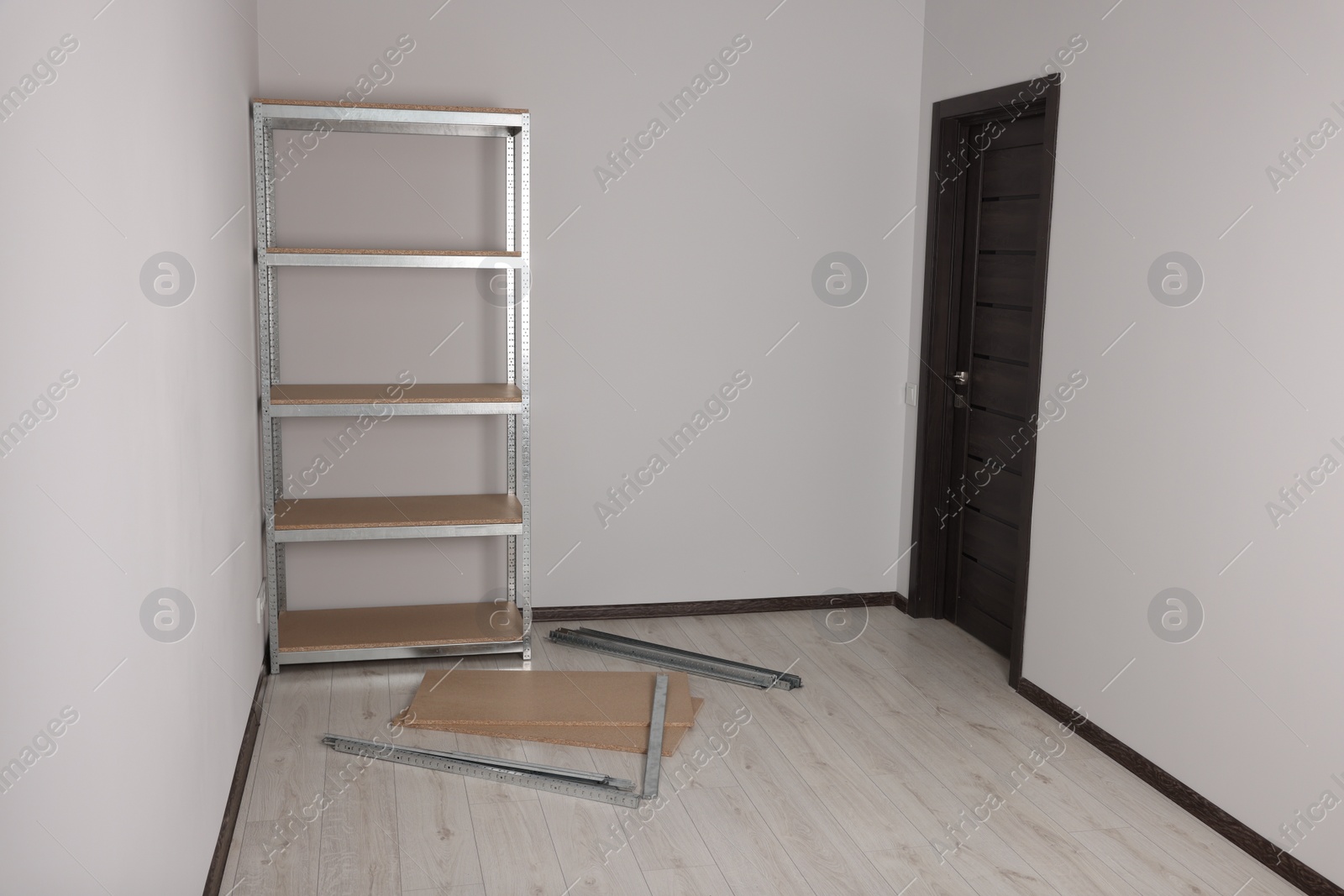 Photo of Office room with white walls and metal storage shelf
