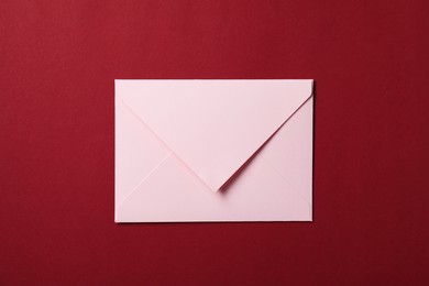 Photo of Letter envelope on red background, top view