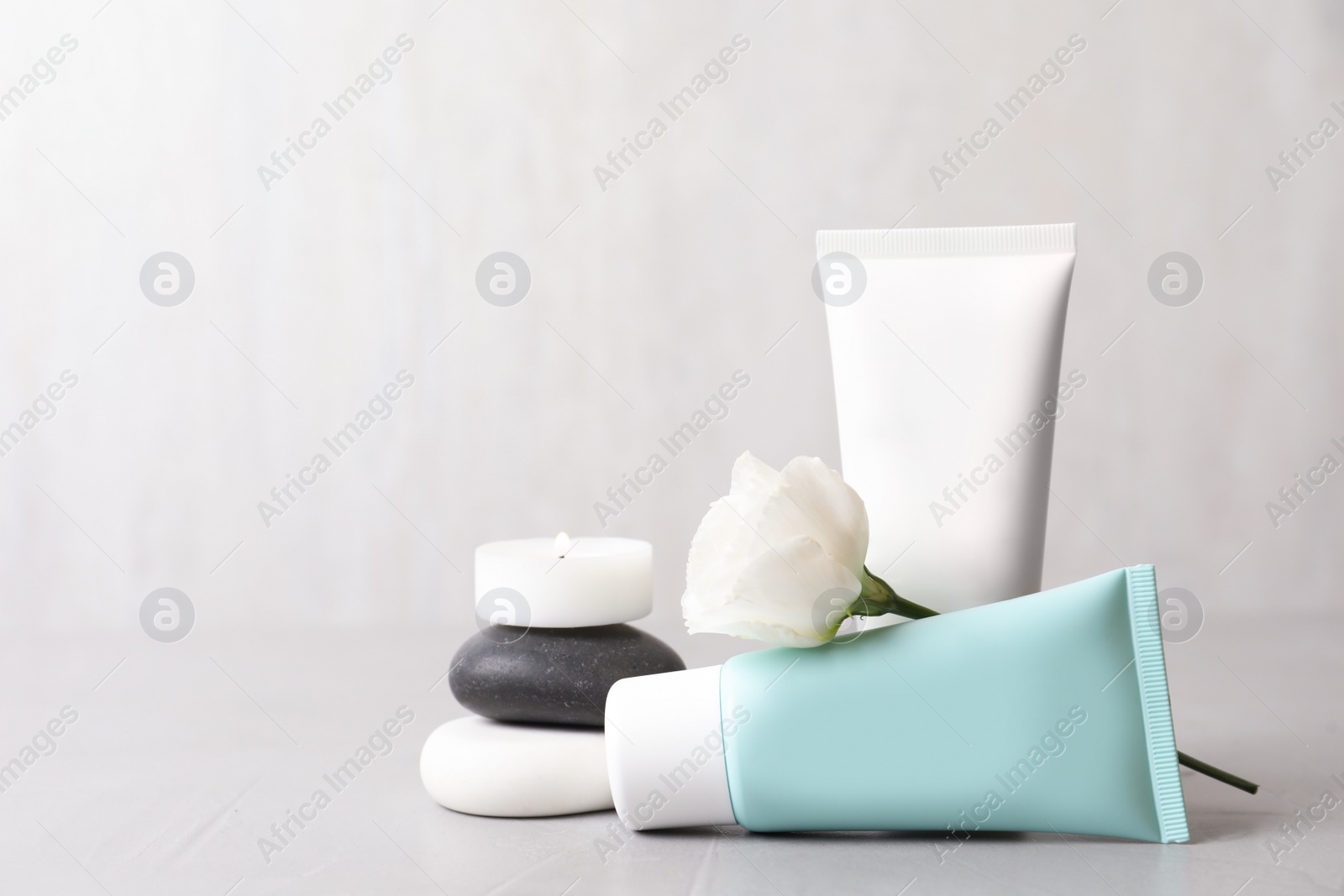 Photo of Composition with cosmetic products on light grey stone table. Space for text