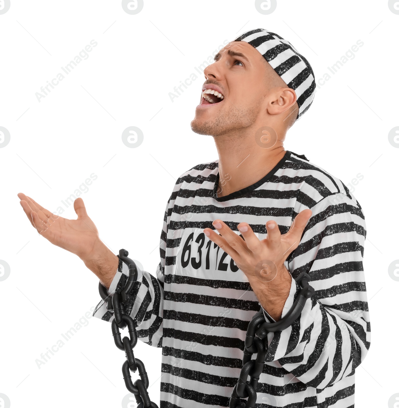 Photo of Emotional prisoner in striped uniform with chained hands on white background