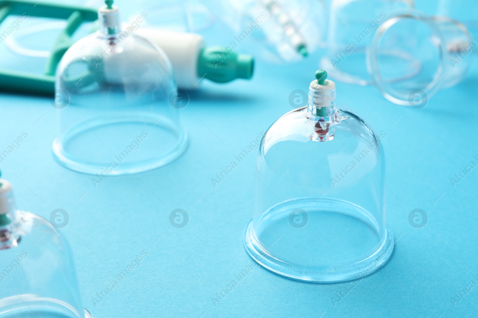 Photo of Plastic cups on light blue background. Cupping therapy