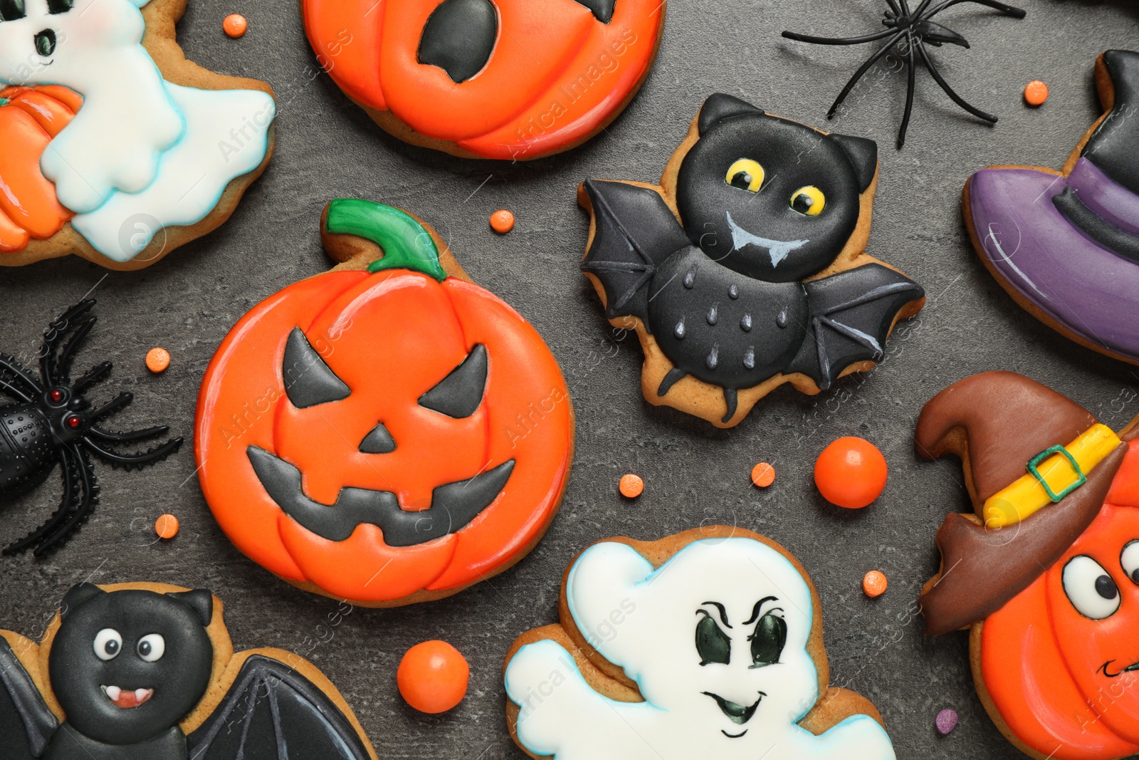 Photo of Tasty cookies and sweets for Halloween party on black table, flat lay