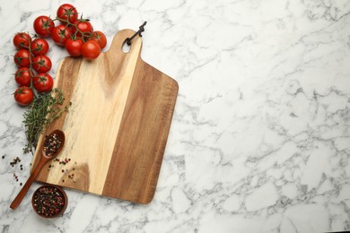 Flat lay composition with wooden cutting board and ingredients on white marble table, space for text. Cooking utensil